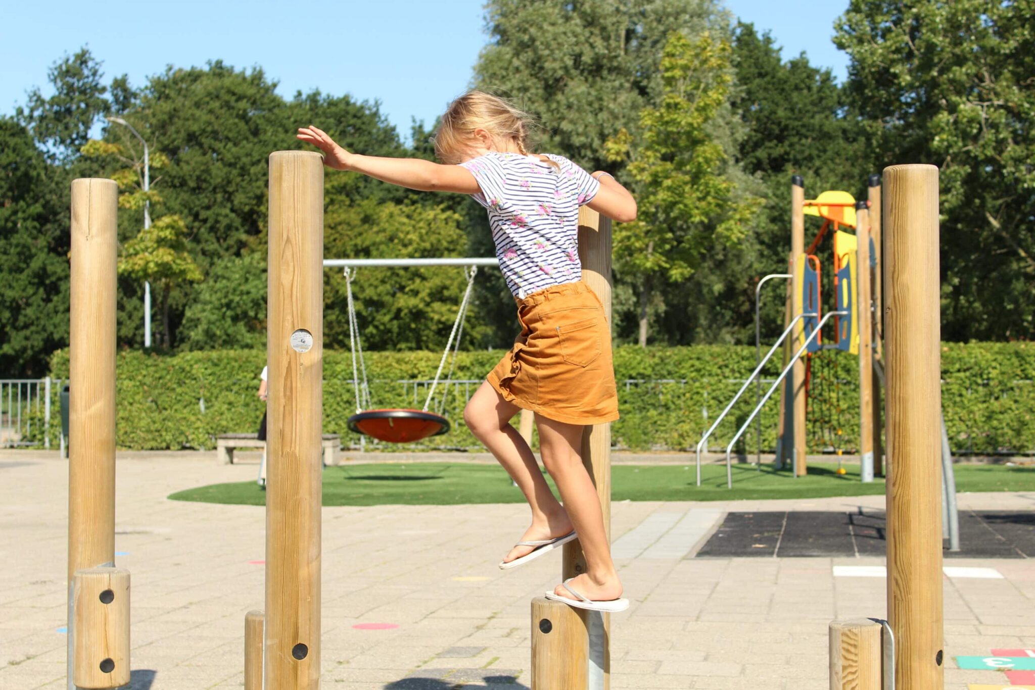 kind op balanceerpalen hout