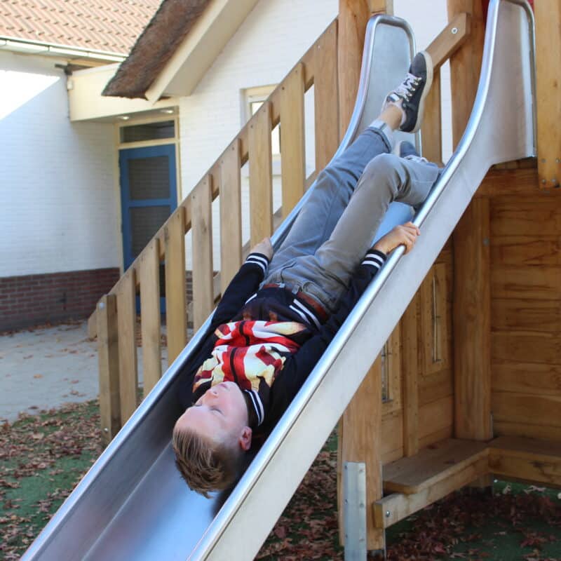 Jongen speelt riscovol op RVS glijbaan
