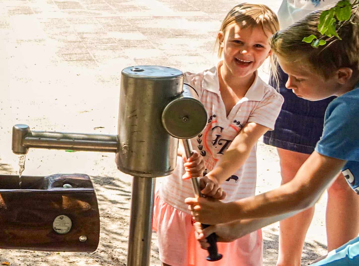 Blijde kinderen bij een waterpomp