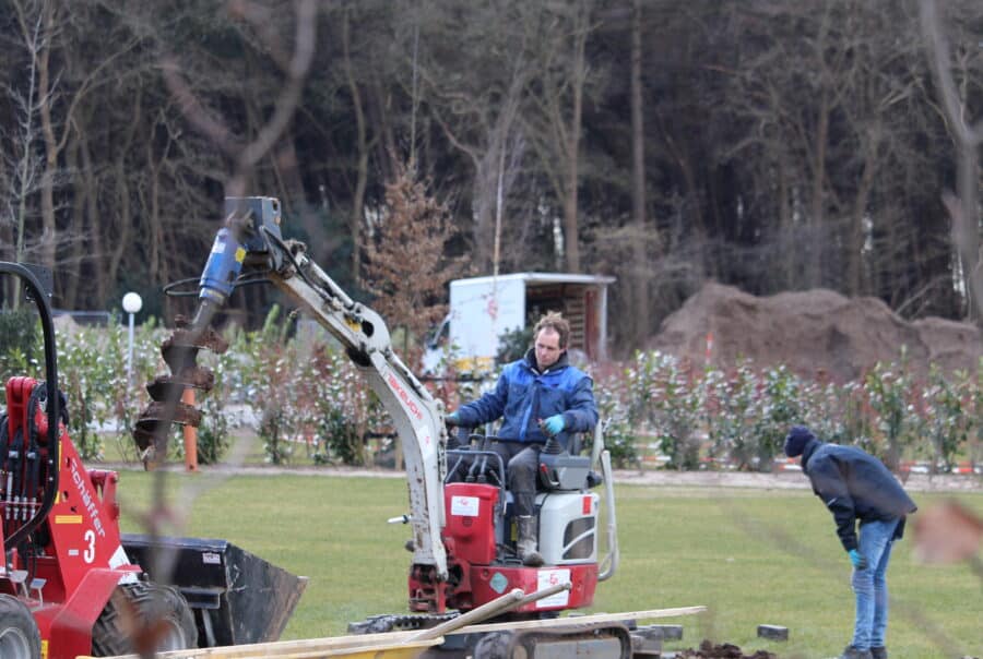 Monteurs met graafmachine